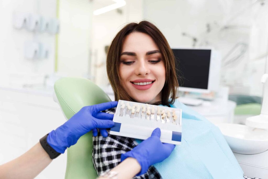 dentist and his patient choose a tone of veneers