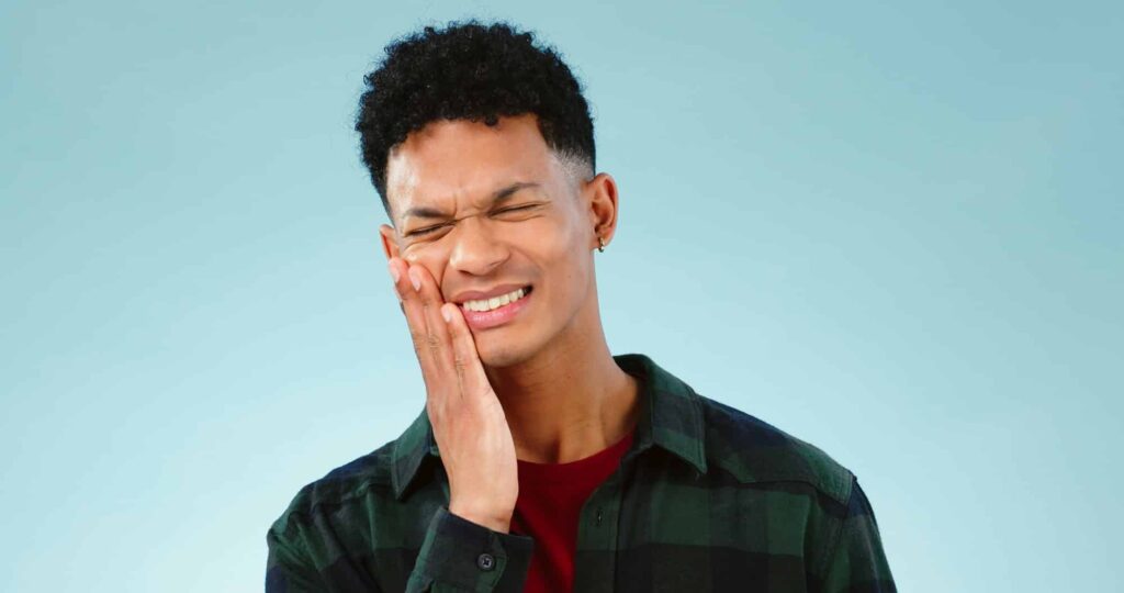 man toothache or pain in studio with gum problem cavity or dental crisis by blue background mode