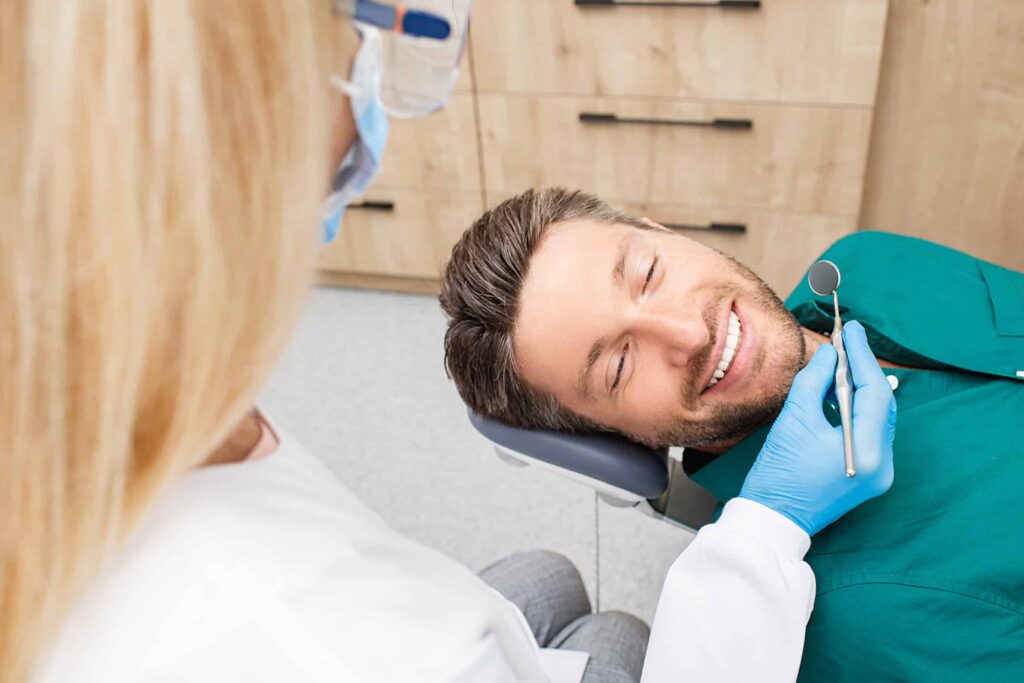 Handsome,Man,Smiling,While,Teeth,Exam.,Happy,Male,Patient,Sitting