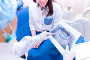 Dentist consulting with patient about her coming full mouth reconstruction for a healthier, brighter smile.
