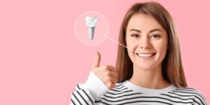 Young woman smiling after receiving a dental implant to replace her missing tooth.